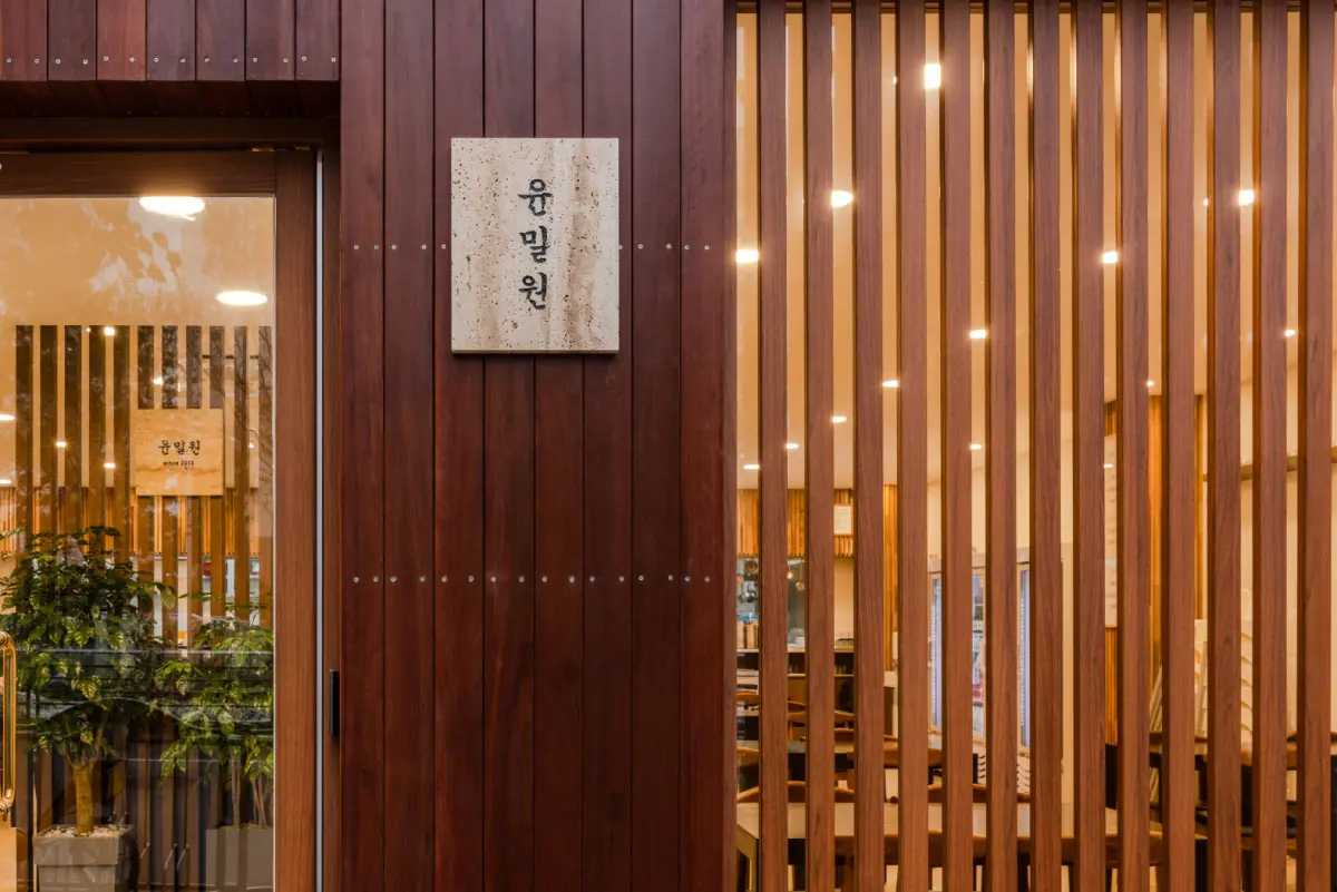 우드 루버와 스팟조명이 어우러진 한식당 외관